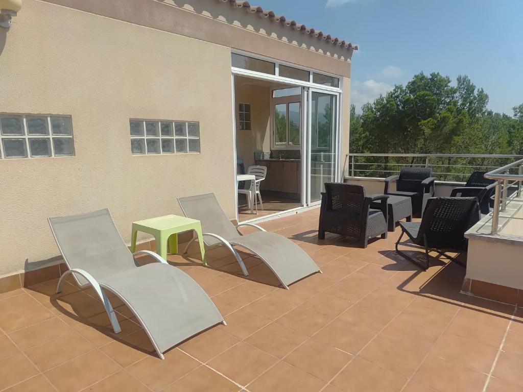 a patio with chairs and a table on a patio at La pineda in Les tres Cales