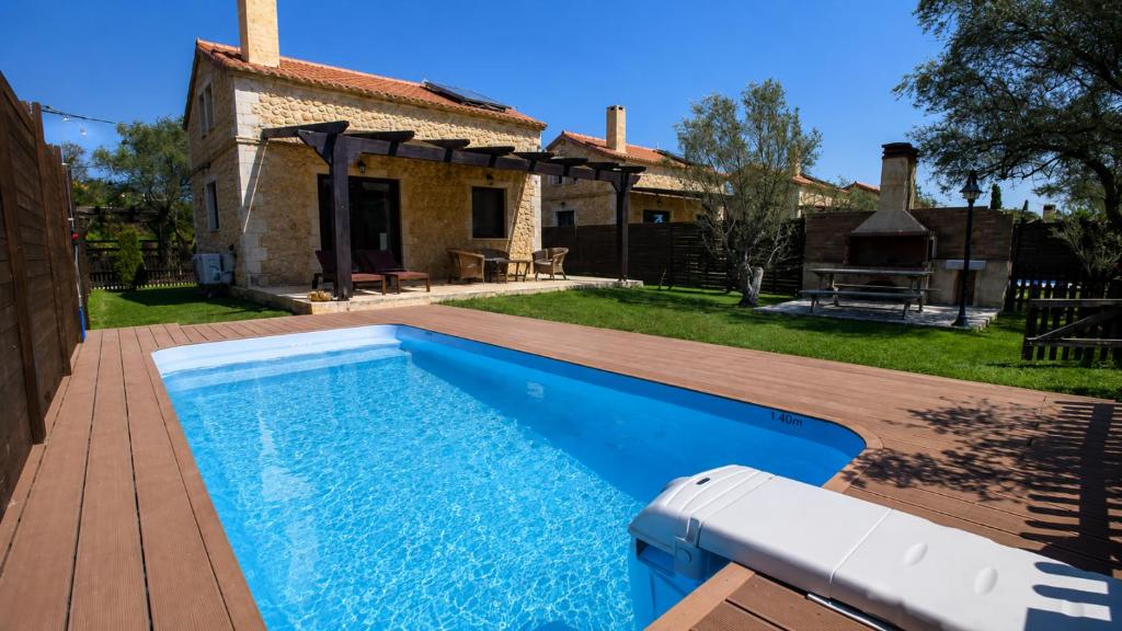 a swimming pool in front of a house at 5 Stars Villas in Svoronata