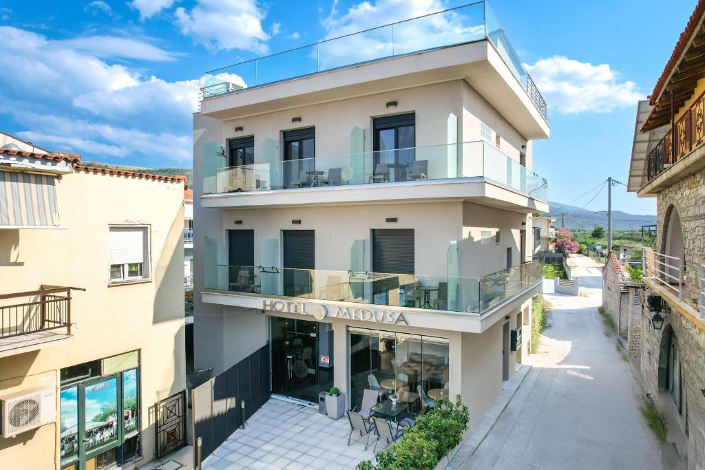 an apartment building with a balcony with a sign that reads hotel pharmacy at Hotel Medusa in Skala Prinou