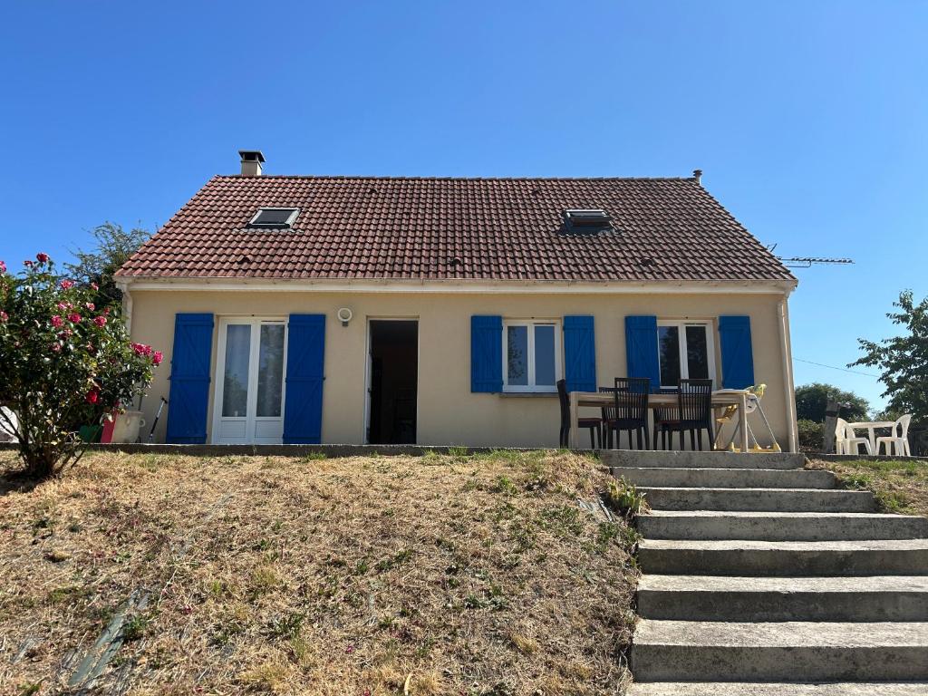 a small house with blue doors and stairs at Maison Grebert in Gouffern en Auge