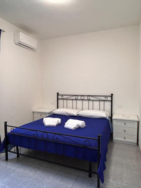 a bedroom with a blue bed with towels on it at Màrila in Aggius