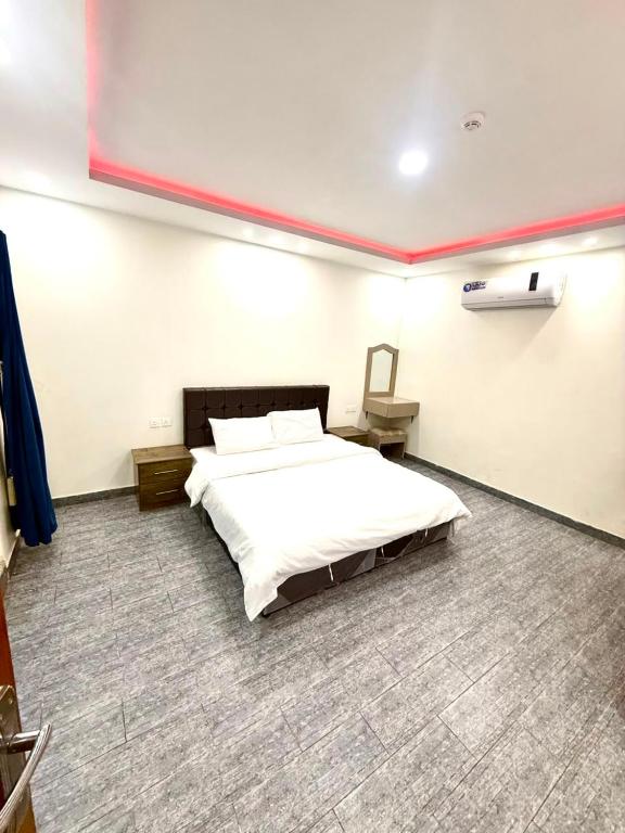 a bedroom with a large white bed in a room at شاليهات زارا 1 in Taif