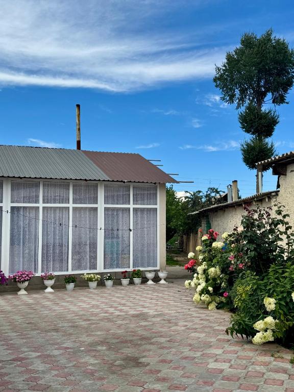 a building with plants and flowers in front of it at Ilgiz Guest House in Bokonbayevo