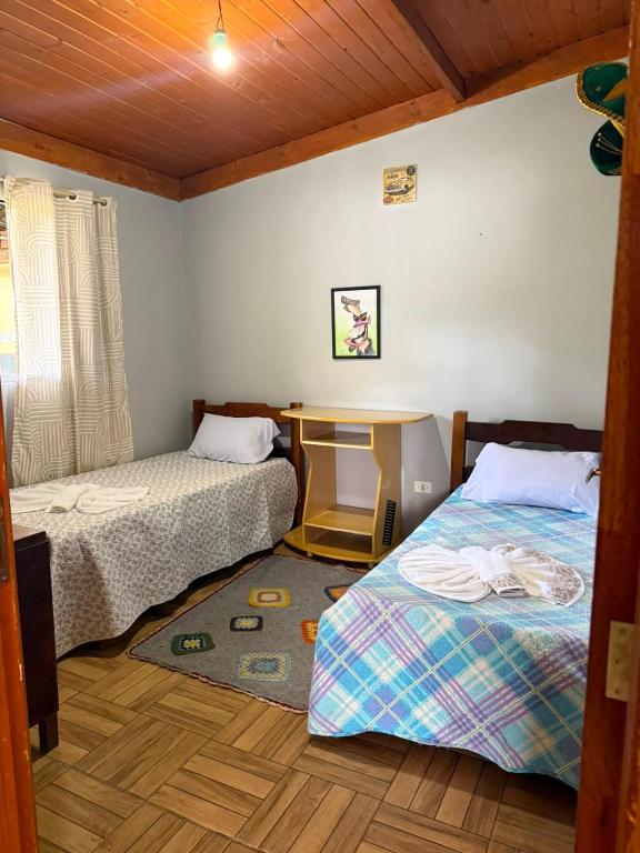 a bedroom with two beds and a desk and a table at Casa verde in Santo Antônio do Pinhal