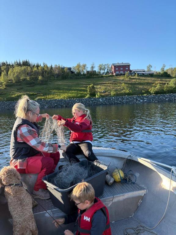 a woman and two children in a boat with a net at Møsstrond Turisthytte in Hovden