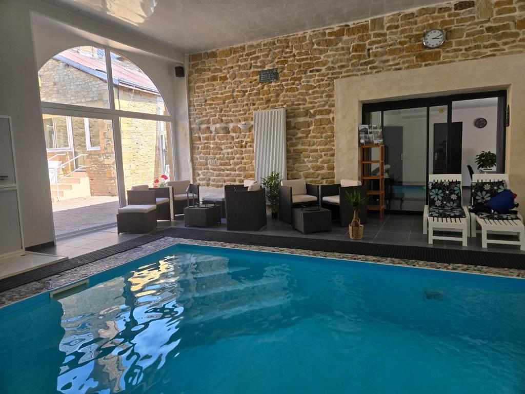 a large swimming pool in a living room with furniture at L'argonnière in Buzancy