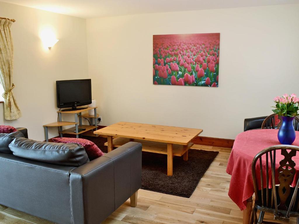 a living room with a couch and a table at Cheviot Cottage in Belford