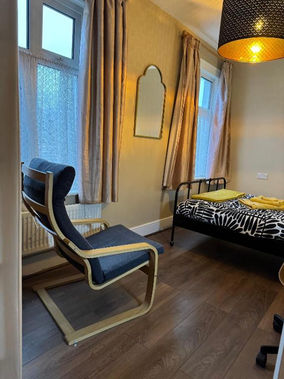a room with a chair and a bed in it at Rectory Cottage in Croydon