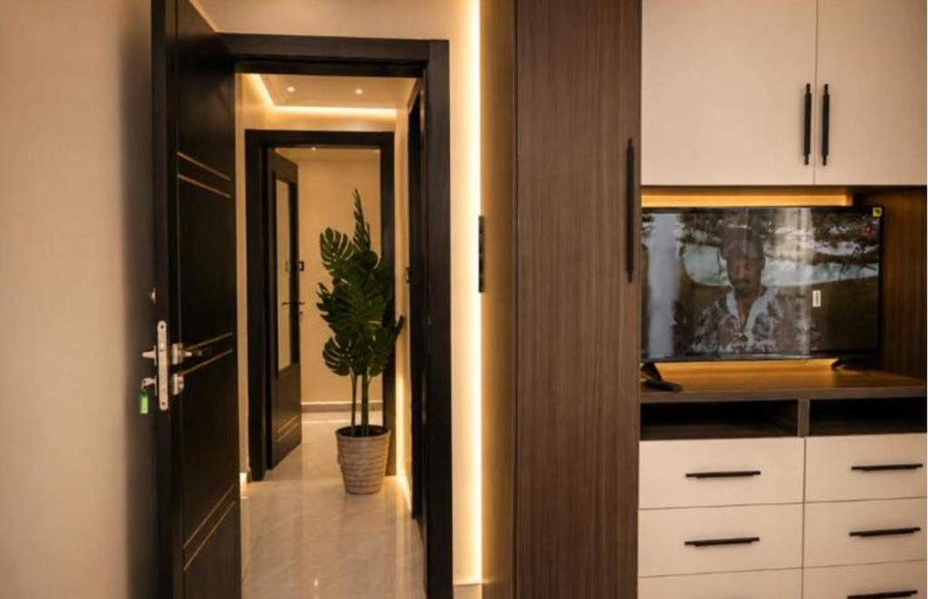 a kitchen with white cabinets and a potted plant at Massa Residence Meublé Yaounde in Yaoundé
