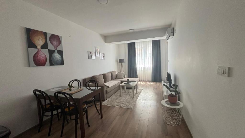 a living room with a table and a couch at M&M Cozy Apartment-Free Parking in Skopje