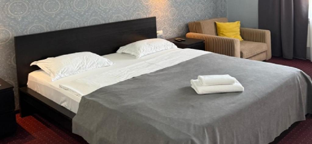 a large bed with two towels on top of it at Oral City Hotel in Oral