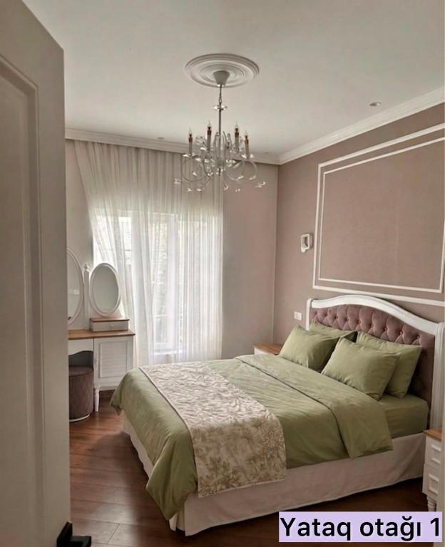 a bedroom with a large bed with a chandelier at Sheki Center Home in Sheki