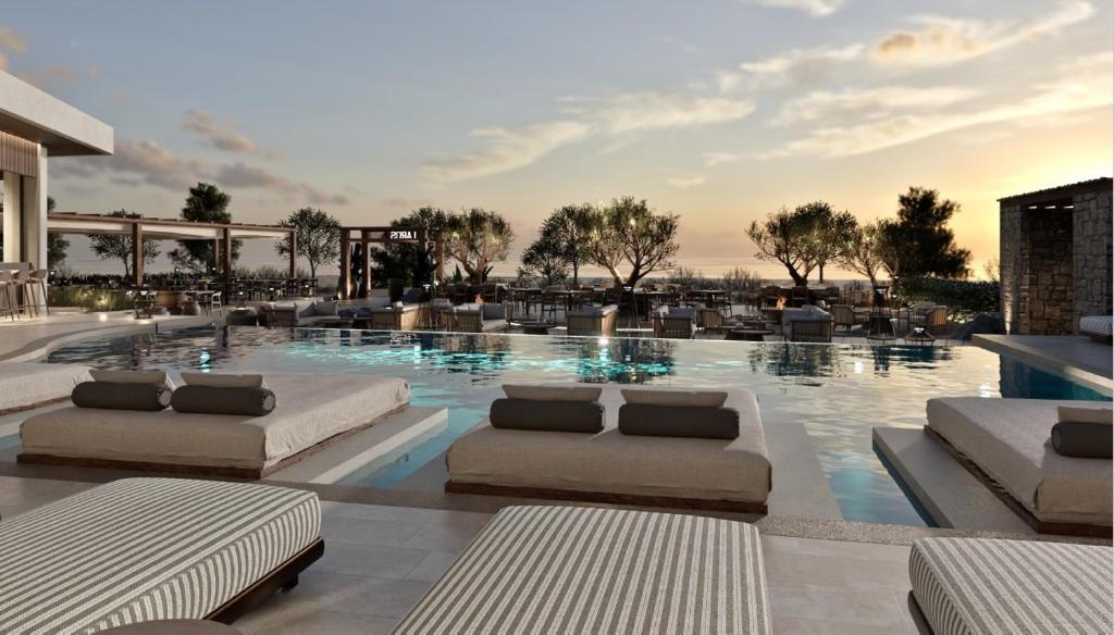 a swimming pool with couches and chairs in a building at Glaronissi Beach in Plaka