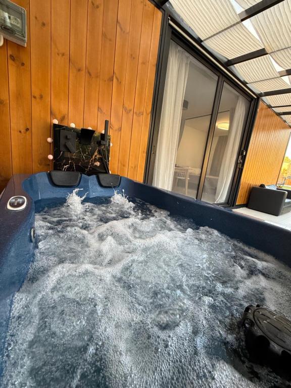 a bath tub filled with water in a room at Grand Relax Suites in Diakopto