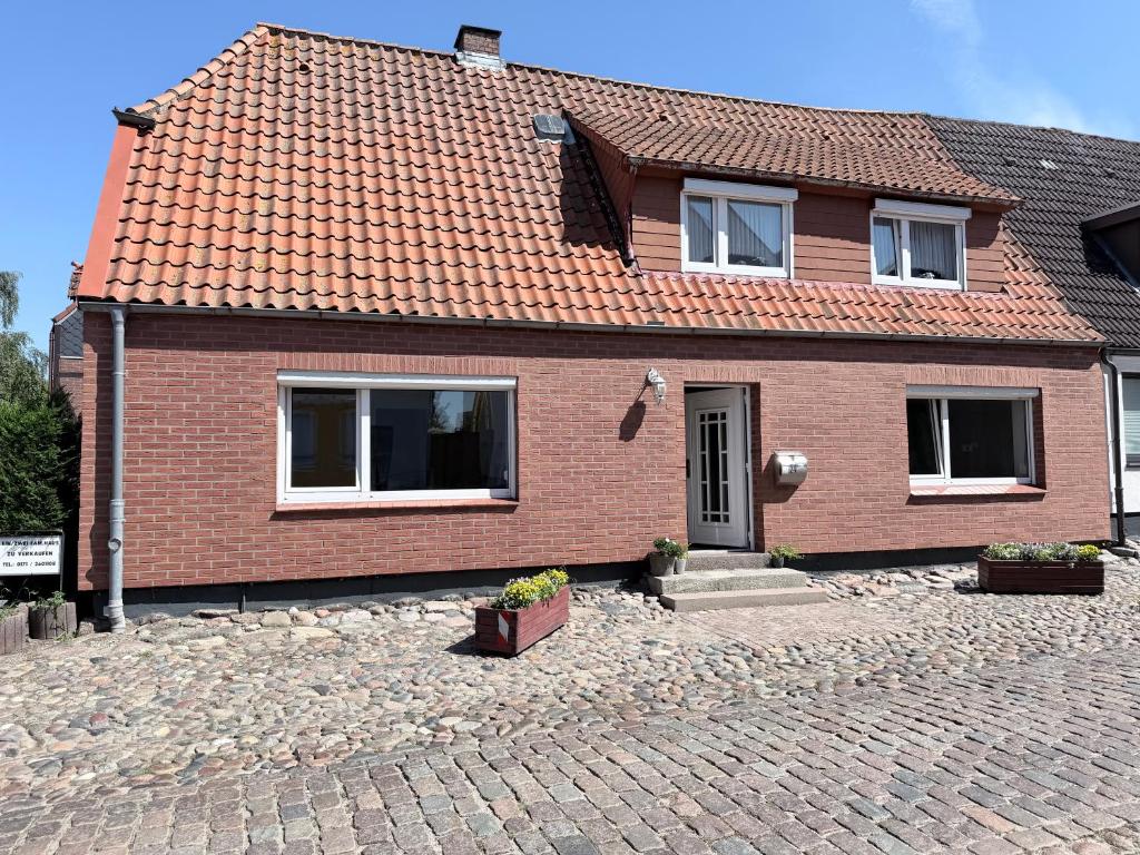 a brick house with windows and a brick driveway at Ferienwohnung am Binnensee 2 in Heiligenhafen