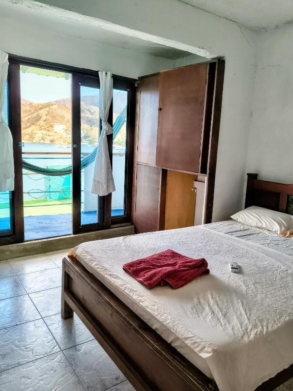 a bedroom with a bed and a large window at Shadday taganga in Santa Marta