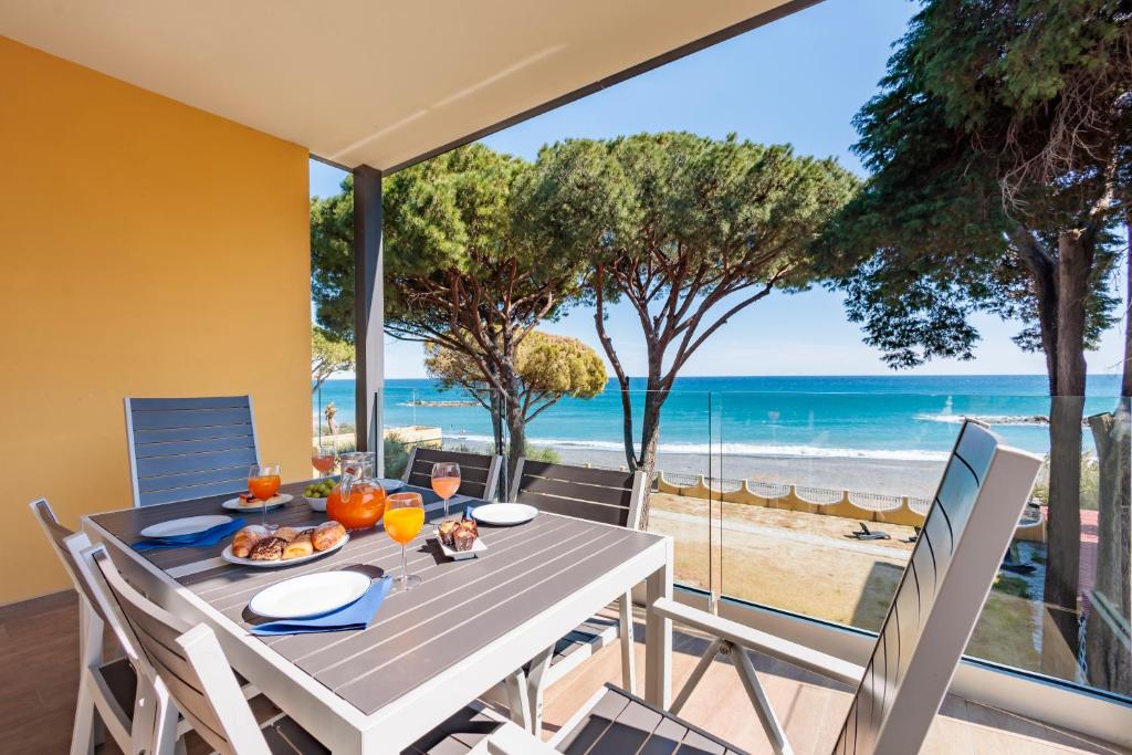 a dining table with a view of the beach at Appartamenti BluMare in Diano Marina