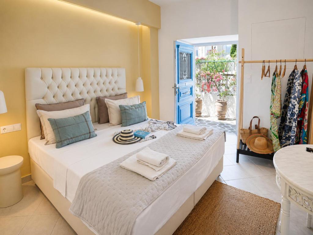 a bedroom with a large white bed with towels on it at Mania Rooms and Studios in Poros