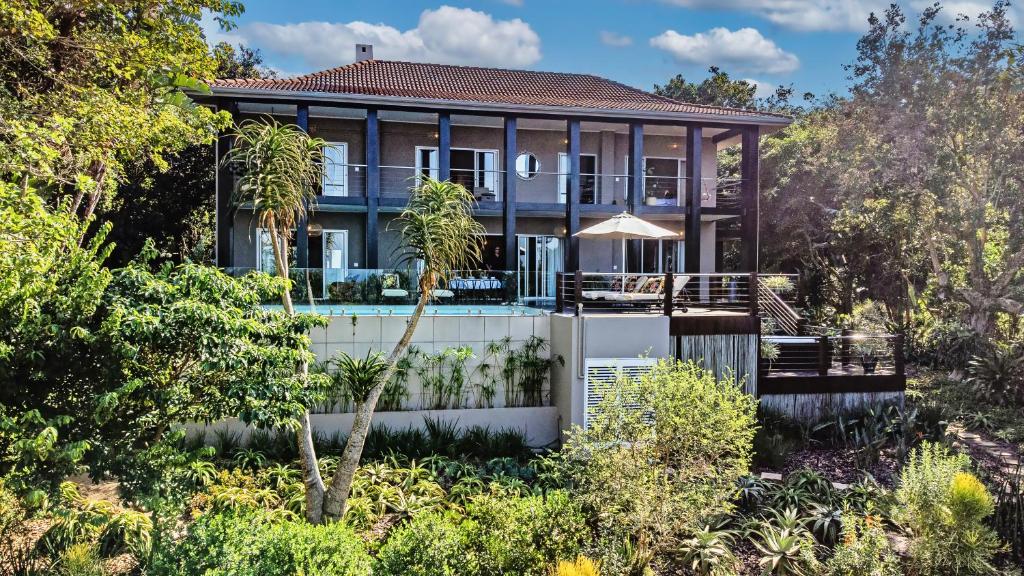 a house with a swimming pool in a garden at Luxury Villa Umdoni - Eden Rock Estate, Pennington in Pennington