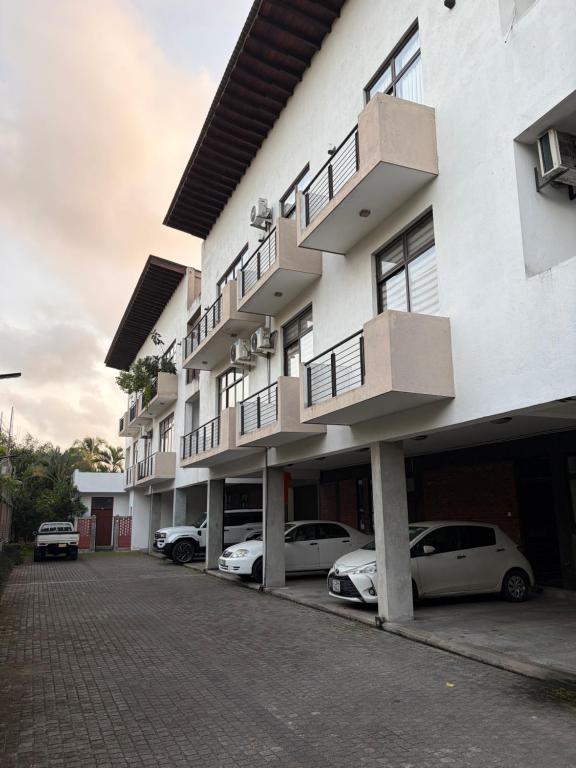 a building with cars parked in a parking lot at Eldorado Apartments F2P3 Wattala in Alwis Town