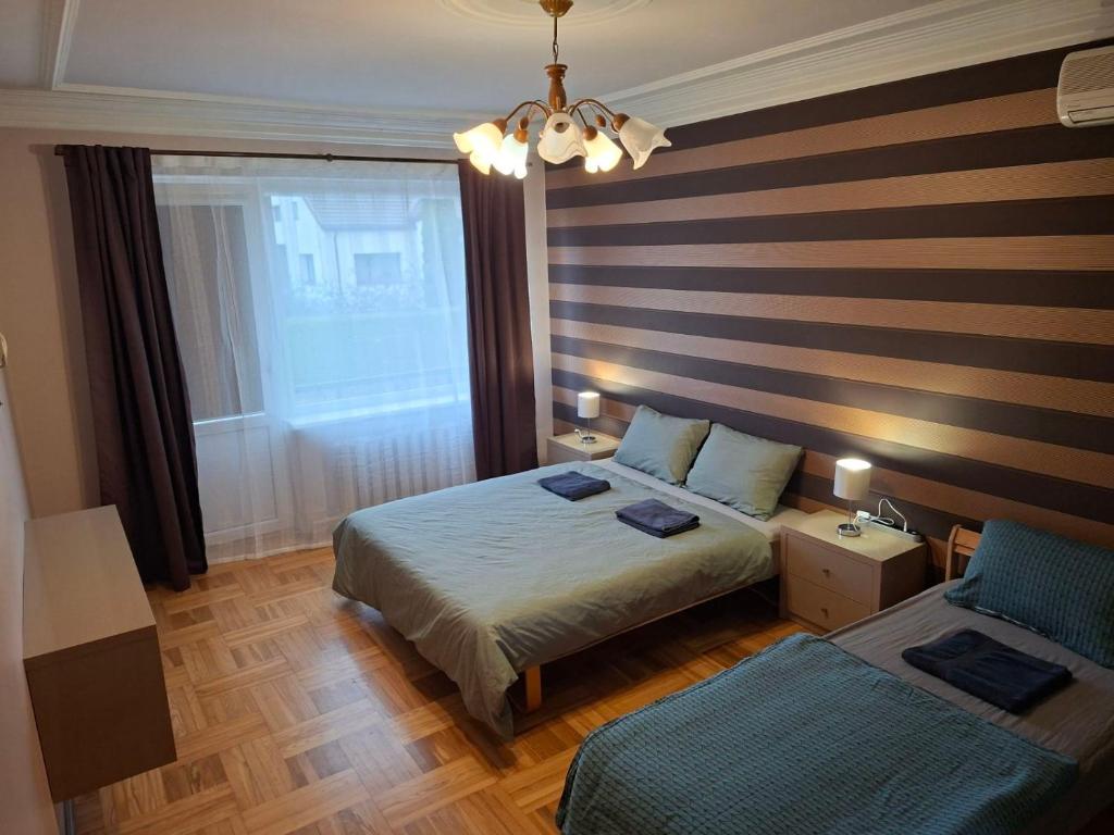 a hotel room with two beds and a window at Azimut Guest House Self Check-in in Šiauliai
