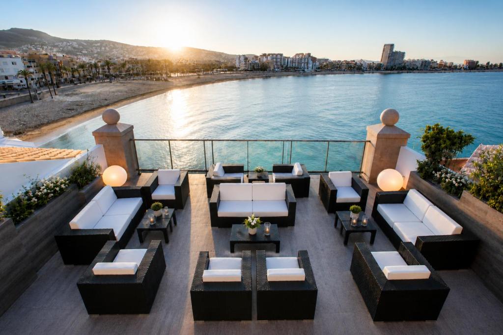an outdoor seating area with a view of the water at Hotel Boutique La Mar - Adults Only in Peniscola