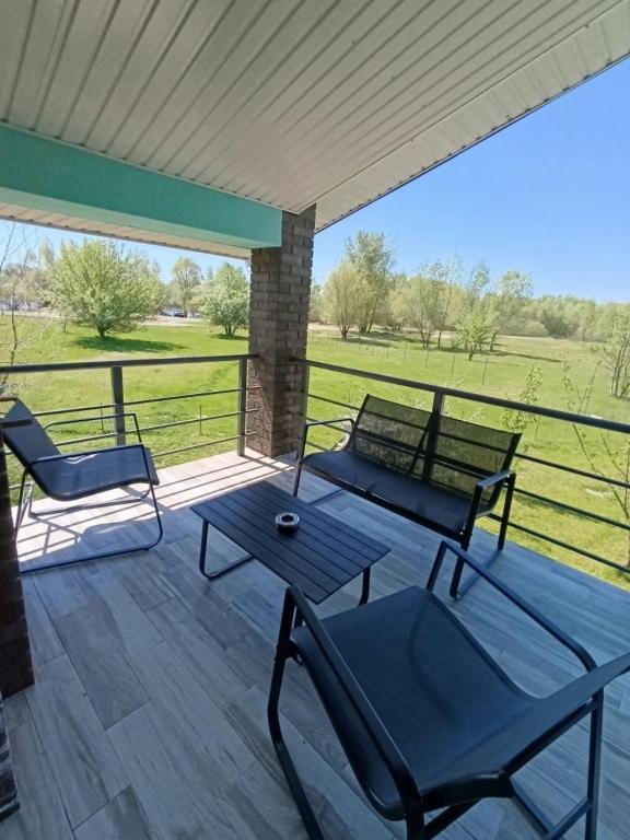 eine Terrasse mit zwei Stühlen und einem Tisch auf einem Deck in der Unterkunft Чабарня in Pukhovka