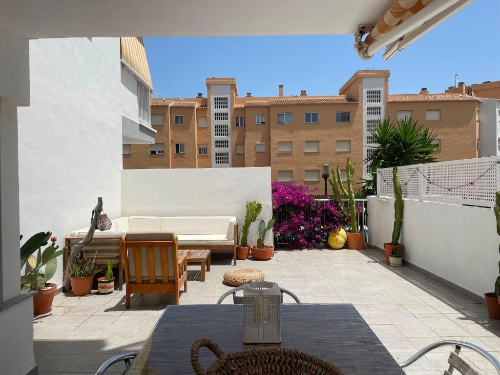 a patio with a couch and a table and chairs at Casa cactus Piles Playa in Piles
