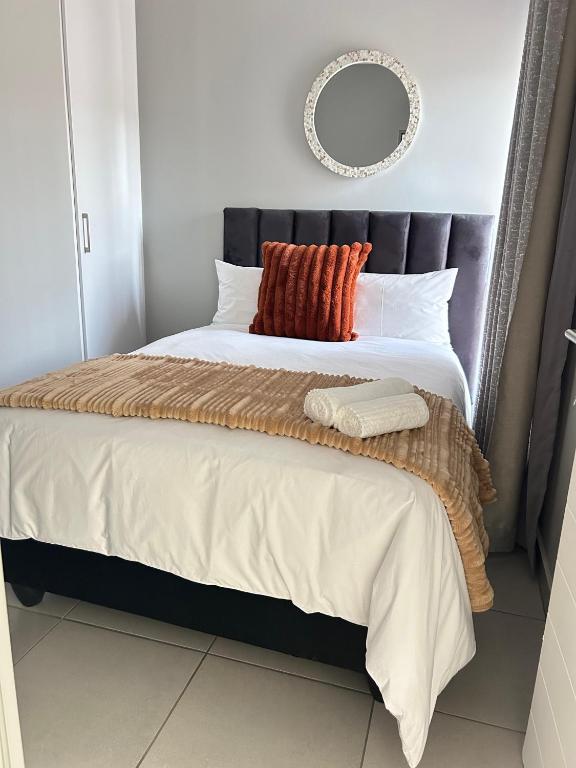 a bedroom with a large bed with a mirror on the wall at 161 green valley in Boschrand