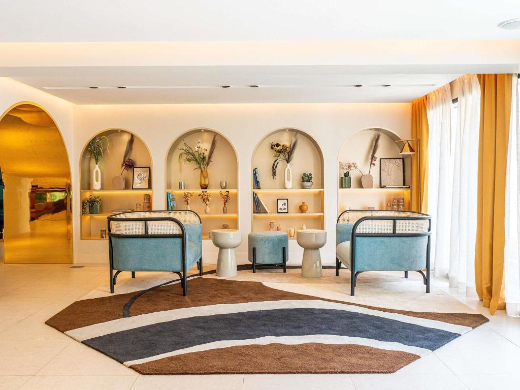 a room with two beds and shelves with vases at Mercure Shéhérazade Rabat in Rabat