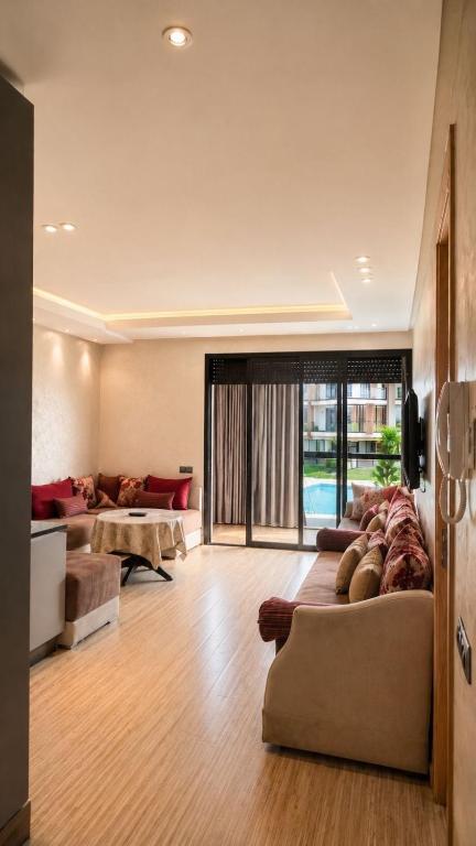 a large living room with a couch and a tv at Relaxing residence oceanic Sidi rhal in Sidi Rahal