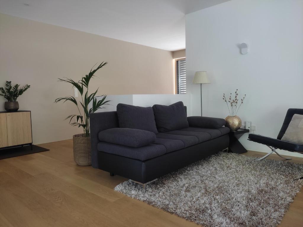 a living room with a black couch and a table at Gardena Living in Ponte Gardena