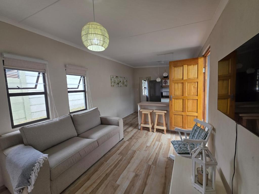 a living room with a couch and a table at Beach cottage in Gonubie Park
