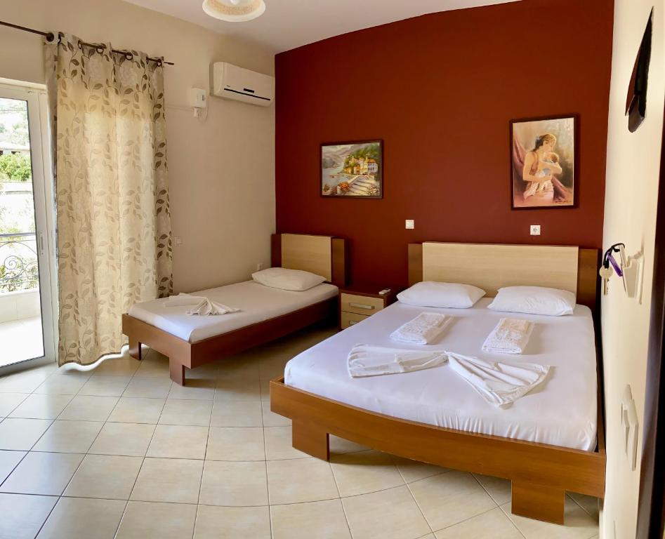 a hotel room with two beds and a window at Dhimitri Rooms in Gjilek