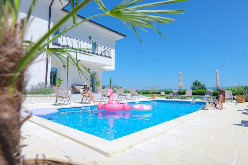 a swimming pool with a pink inflatable raft in a house at Vila sa bazenom Vrnjačka Idila in Vrnjačka Banja