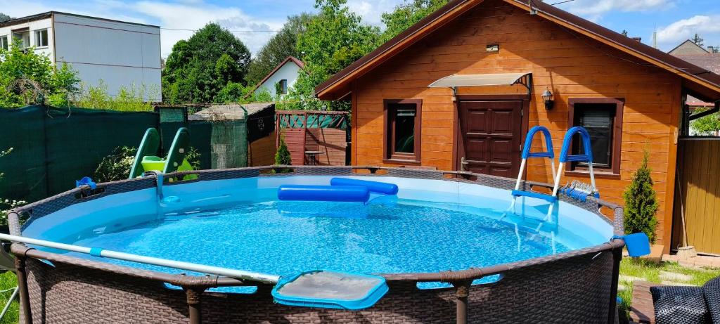 a swimming pool with a house in the background at Tiny Treperka in Semily