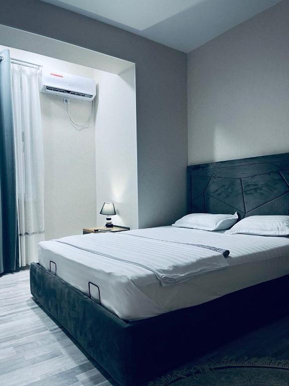 a bedroom with a large bed and a air conditioner at Стильная студия в центре с кухней in Bukhara