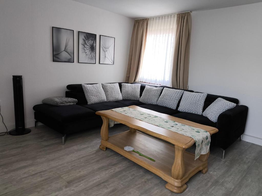 a living room with a black couch and a coffee table at FeWo Antweiler Oberdorf in Mechernich