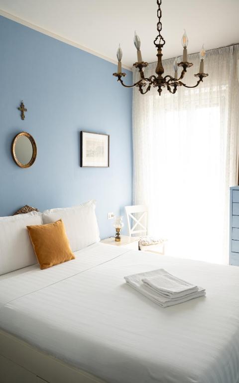 una camera da letto con un grande letto bianco con una finestra di SanSi a Milano