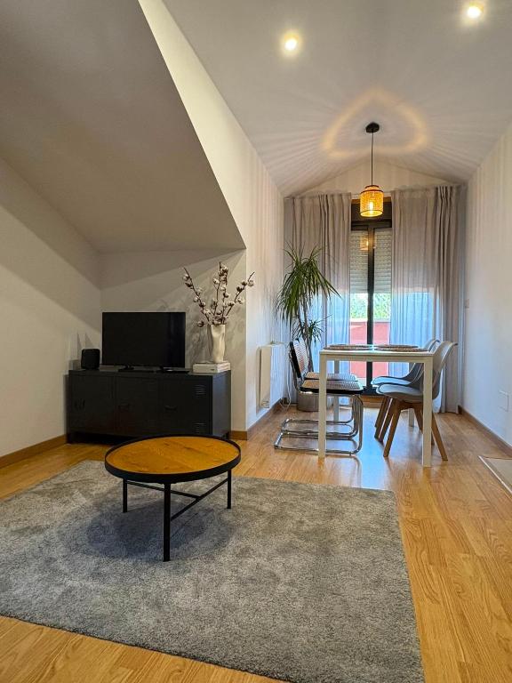 a living room with a table and a dining room at O Ático in Rosal