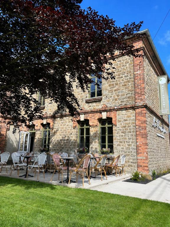 a patio with tables and chairs in front of a brick building at Le Presbytère in Ambleteuse