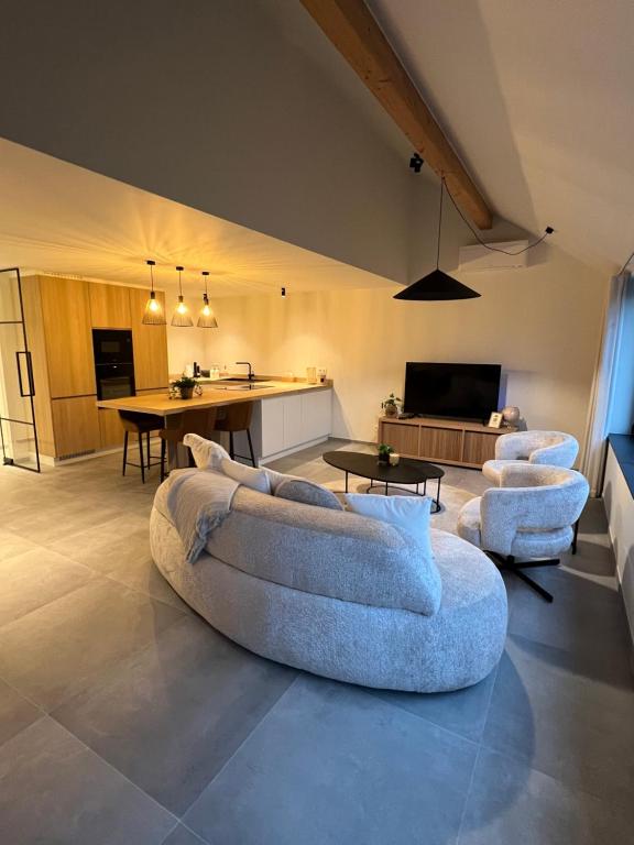 a living room with a couch and chairs in a room at Hartje Borgloon in Borgloon