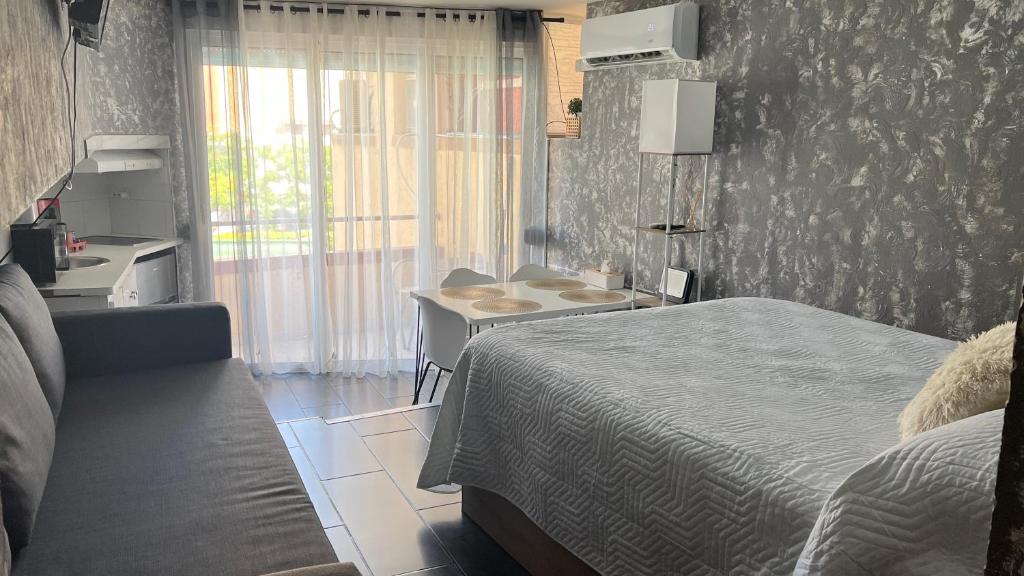 a bedroom with a bed and a desk and a window at Estudio Loft in La Pineda