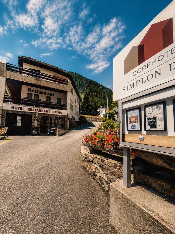 a building with a sign on the side of a street at Dorfhotel Simplon Dorf in Simplon Dorf