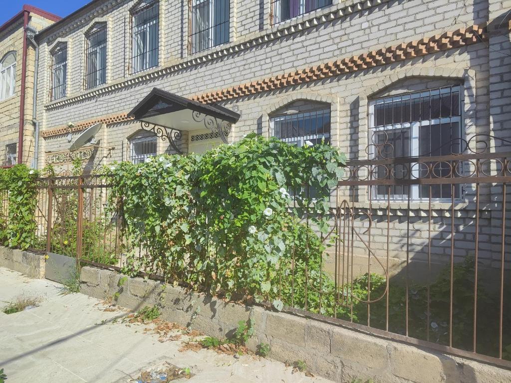 a fence in front of a brick building at Bright Modern Suite in Quba