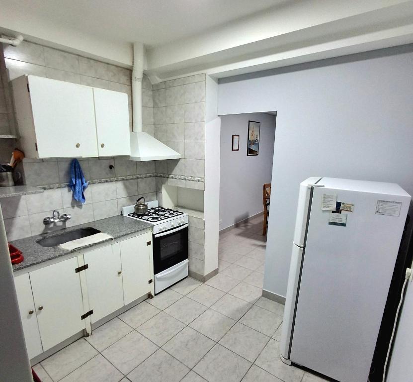 a kitchen with white cabinets and a white refrigerator at Ayinmai in Trelew