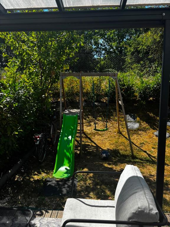 a green slide in front of a swing at Disney - Résidence Juan Valera in Vaujours