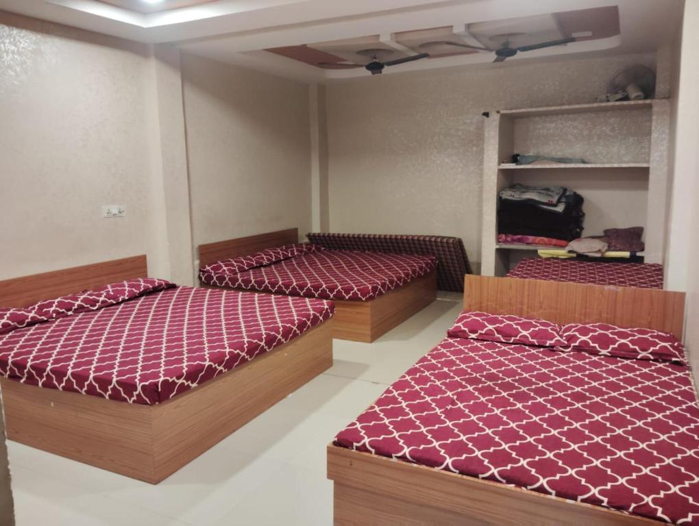 two beds in a room with red comforter at Nandan Palace in Godarpura