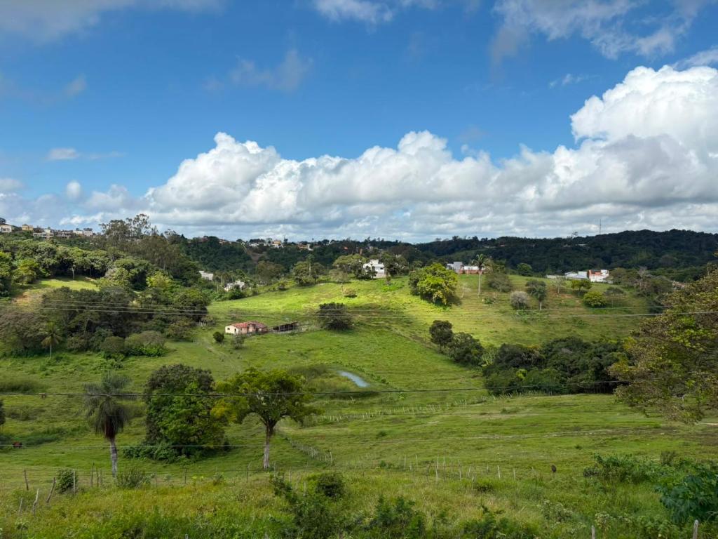 a green field with trees and houses on a hill at Kitnet Vista do Vale in Areia