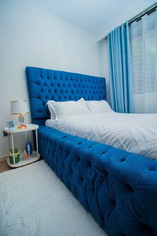 a blue bed with a blue headboard in a bedroom at Beryl's Haven in Marimbeti